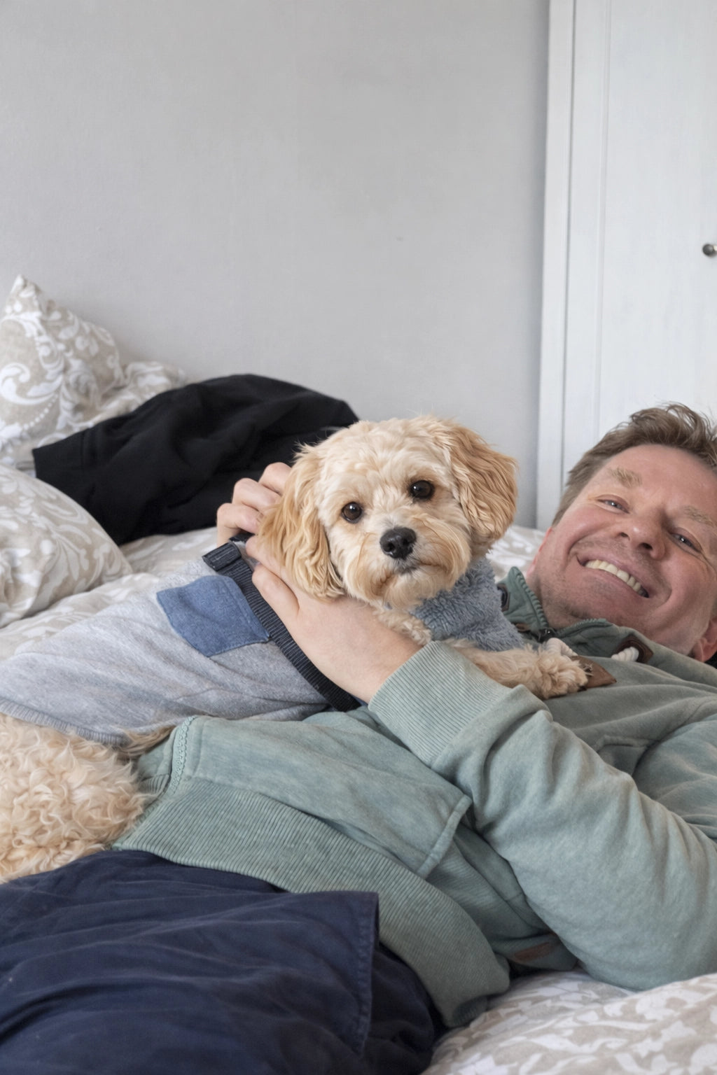 Stephan Schwarze, Mitgründer von SnoozenPaws, liegend auf einem Sofa mit einem Hund in den Armen